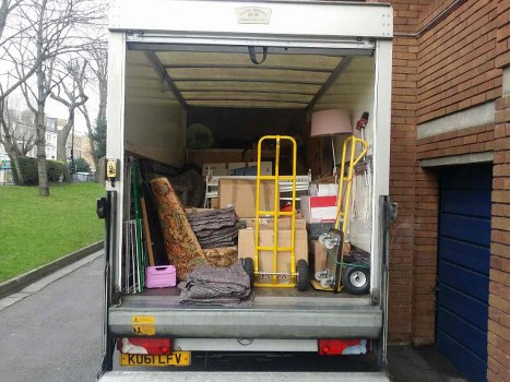 Volunteers loading reusable furniture into a charity van